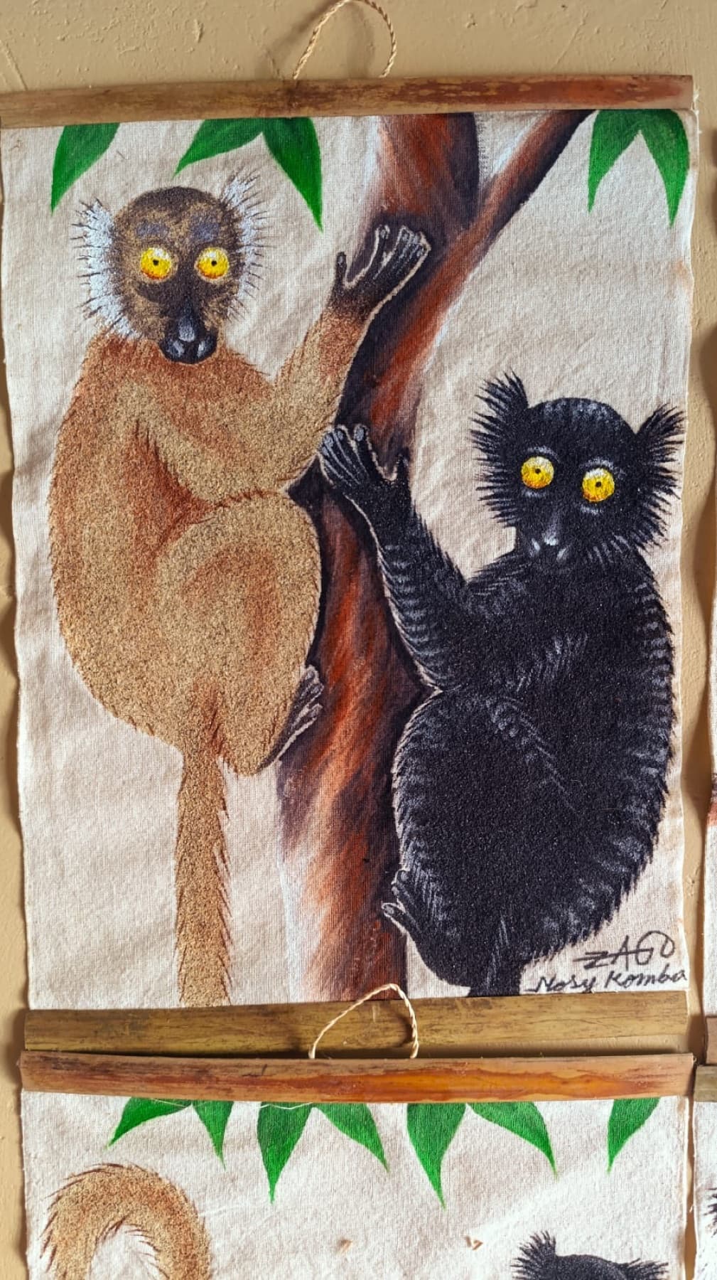 Peinture de deux lémuriens dans un arbre, l'un au pelage brun clair, l'autre noir aux yeux orange vif, accrochés de part et d'autre du tronc.